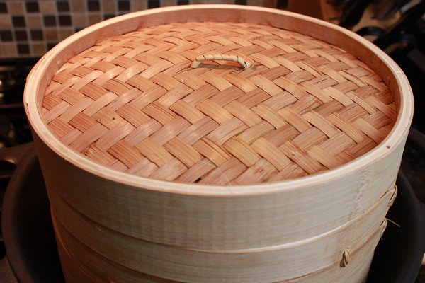 A bamboo steamer with lid on.