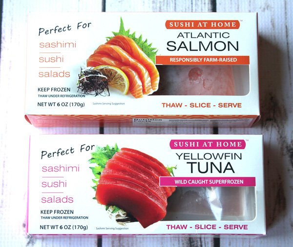 Sushi at Home Atlantic salmon and yellowfin tuna in packages on top of a white wooden board