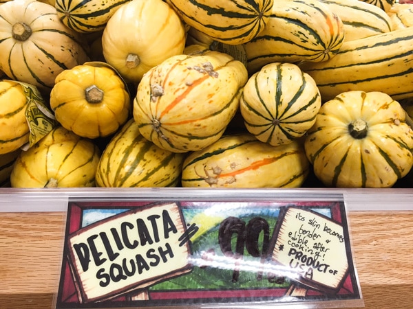 delicata squash Whole delicata squash on display at Trader Joe's with a sign with the price.