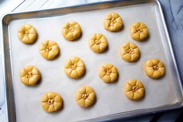 raw pumpkin cookies on a baking tray on top of parchment paper ready to be baked