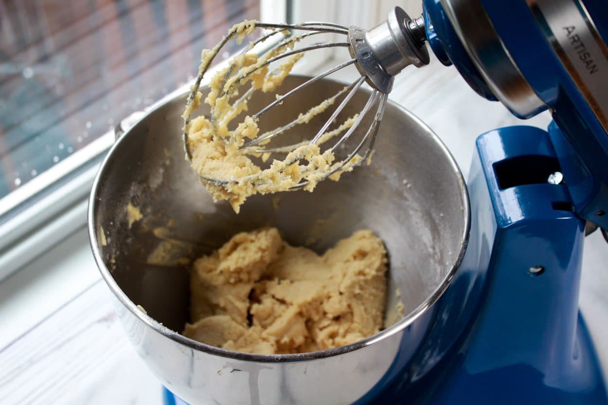 A stainless KitchenAid mixing bowl fill with sugar cookie batter