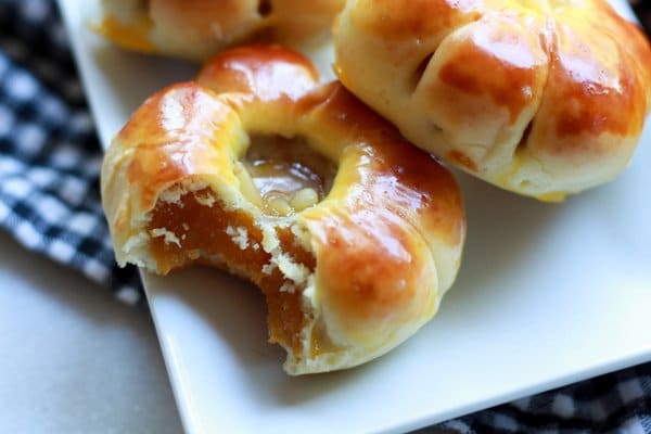 close up of pumpkin manju cookies on a white plate
