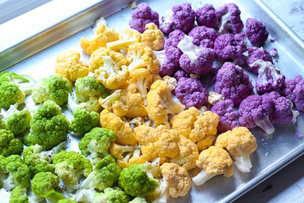 roasted cauliflower Chopped purple, orange and green cauliflower florets on a sheet pan ready for the oven.