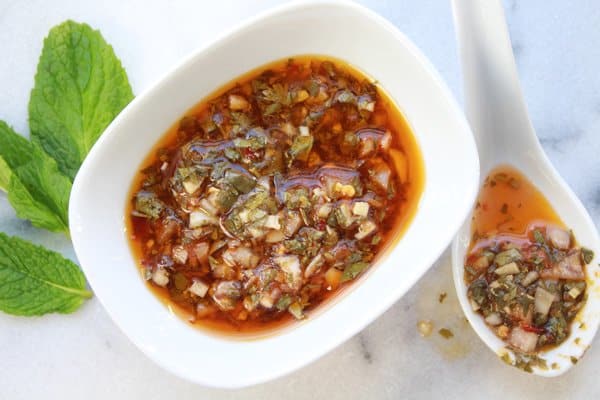 nuoc cham nuoc cham dipping sauce in a small white bowl with a white spoon along side