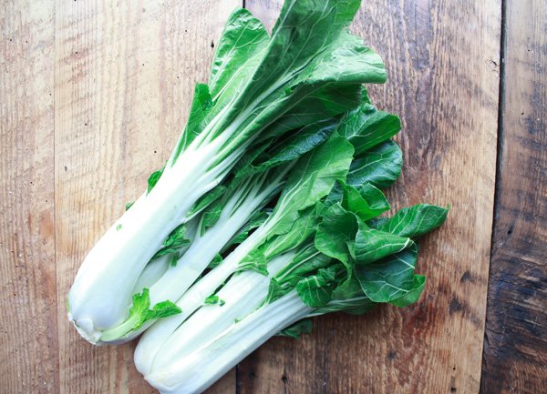 bok choy two bunches of bok choy on a wooden cutting board