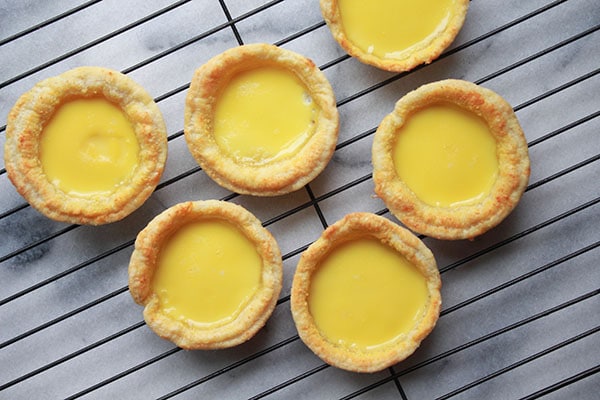 Chinese egg custard tarts on a cooling rack