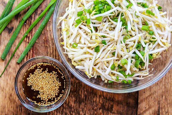 mung bean sprouts Fresh bean sprouts salad in a glass bowl with green onions and dressing on the side