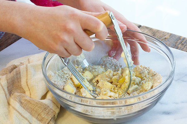 oats crumble oats crumble being mixed together in a glass bowl on top of a marble board