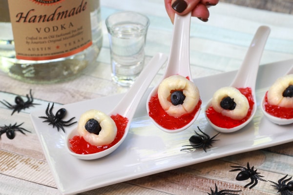 creepy eyeball jello shots Lychee eyeball jello shots on small white serving spoons and fake spiders along side