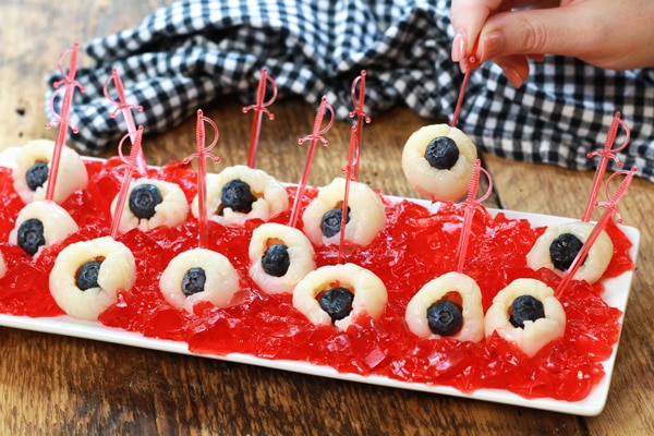 eyeball jello shots A white tray with lychee eyeballs on top of strawberry jello