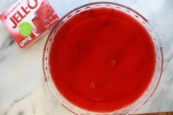 jello strawberry jello in a clear glass pie pan with the Jello box on the side