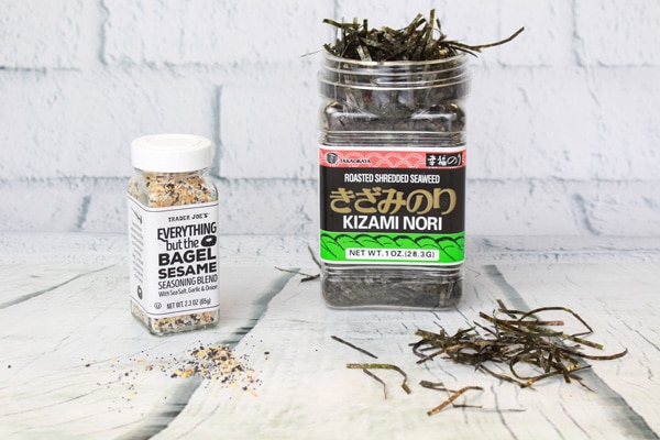 Everything Bagel Seasoning and nori strips on top of a white wooden board.