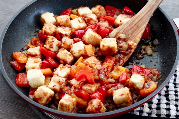 Healthy Vegetarian Sweet and Sour Tofu crispy tofu cubes in a skillet tossed in a sweet and sour sauce.