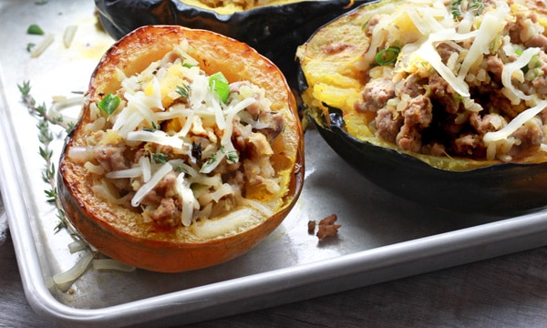 stuffed acorn squash stuffed roasted acorn squash with ground turkey on baking tray.