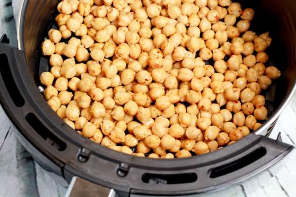 spiced chickpeas in an air fryer basket.