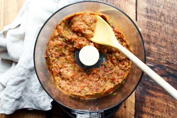 roasted Chinese eggplant dip in the food processor with a wooden spoon.
