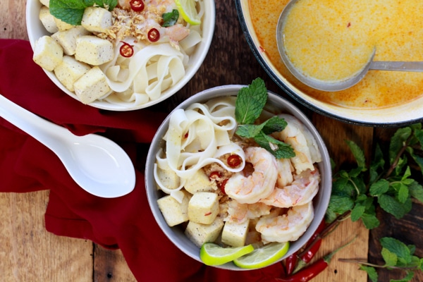 Singapore laksa recipe Singapore laksa with shrimp, tofu, and rice noodles in a bowl and in a Dutch oven with ladel