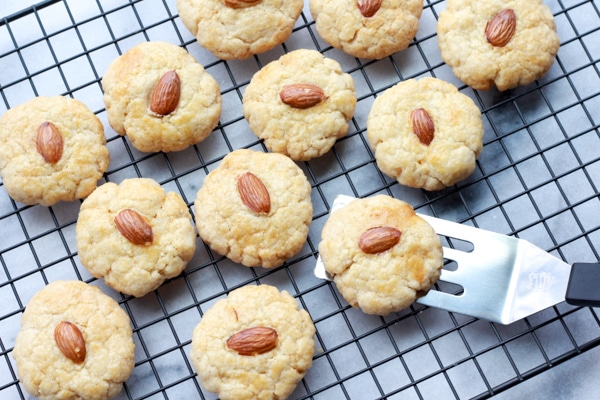 Chinese almond cookies on cooling rack Chinese almond cookies on a cooling rack right out of the oven with a small spatula.