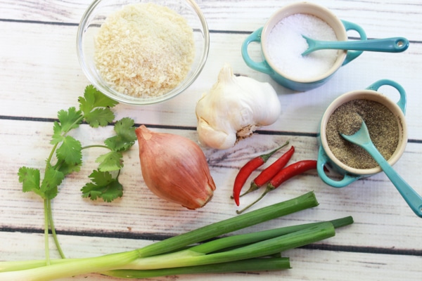 ingredients for making spicy baked shrimp balls recipe on top of a white wooden board