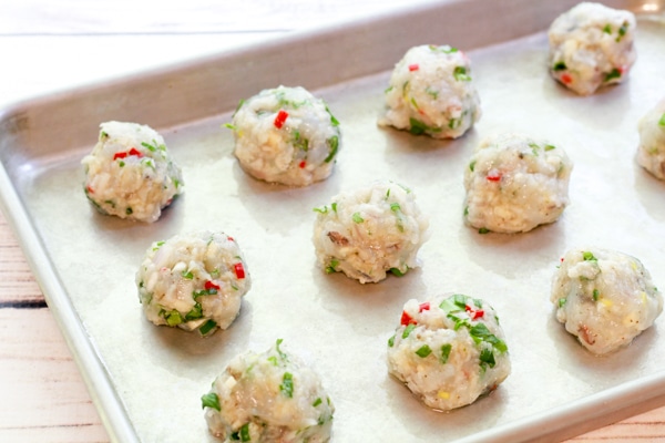 raw shrimp balls in rows on a baking tray ready to be put in the oven for baking