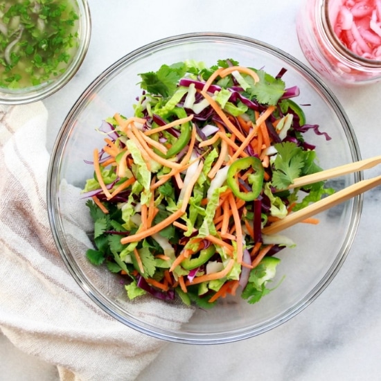 fresh veggie ingredients for making Nuoc Cham slaw in a glass bowl with pickled red onions on the side