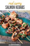 red curry salmon kebabs on a plate with a drizzle of aioli sauce