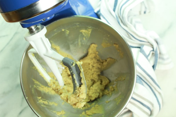 Matcha donut batter inside a blue stand mixer with a white paddle