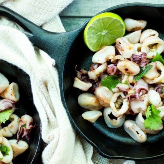 steamed Chinese shumai shrimp and turkey sausage dumplings on a brown square plate with a side of sweet chili dipping sauce