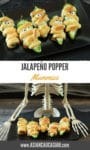 Scary Halloween Jalapeño Popper Mummies on a black plate