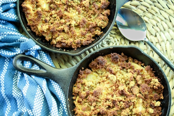 apple crisps in mini cast iron skillets with a spoon and napkin on the side