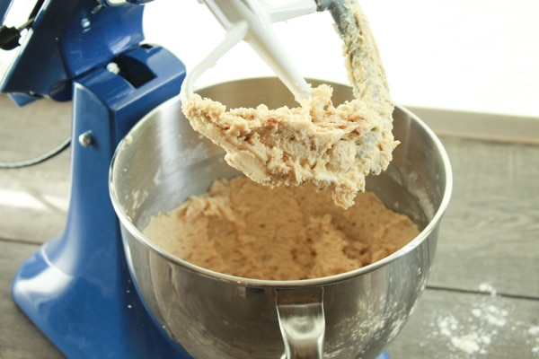 sugar cookie dough in a blue Kitchen Aid mixer on top of a wooden board