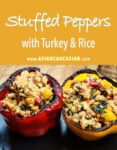 stuffed yellow bell peppers with turkey and rice on a wooden board