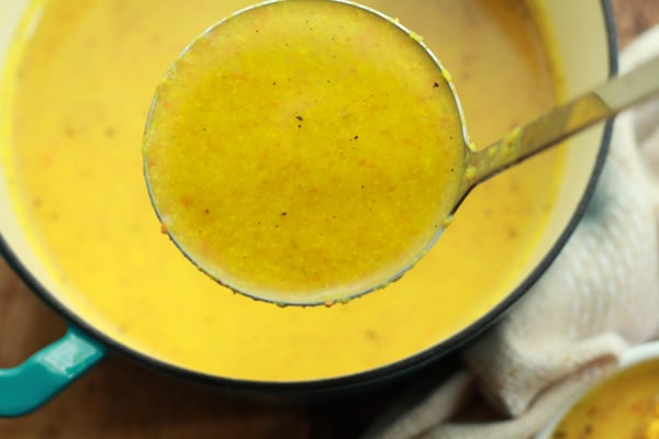 vibrant cauliflower soup in a large stock pot with a ladle