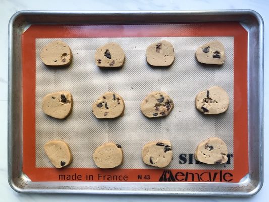 raw chocolate chip cookies on a silicone mat ready for the oven