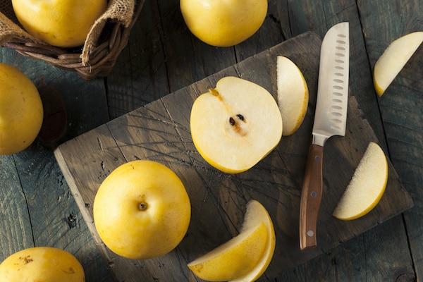 Asian pears on a wooden board with a slicing knife