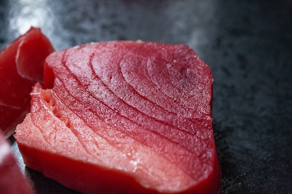 a raw tuna steak on top of a black board