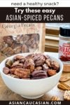 A white bowl filled with golden toasted spiced pecans on a wooden boards with a bag of pecans and sriracha seasoning behind it and loose pecans on the board.