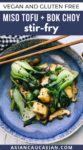 Stir-fry miso shiitake mushrooms, tofu, and baby bok choy on a blue plate with wooden chopsticks, and fresh shiitake mushrooms on the side.