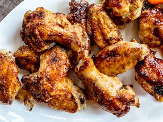 Saucy Japanese whiskey chicken wings on a white platter.