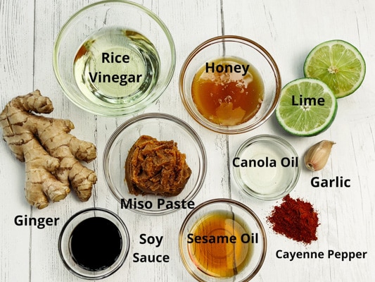 Labeled ingredients for miso ginger dressing on top of a white board.