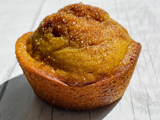 A single pumpkin muffin on a white board.