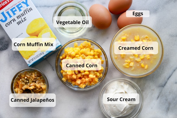 Labeled ingredients for making skillet jalapeño corn bread on top of a marble board.