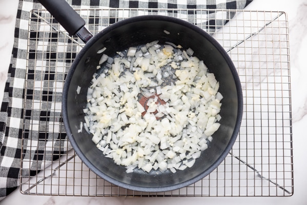 Chopped onions cooked in a frying pan on top of a wire rack.