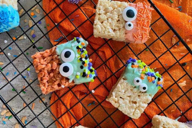 squares of decorated Halloween marshmallow treats made out of rice crispies on top of a baking rack