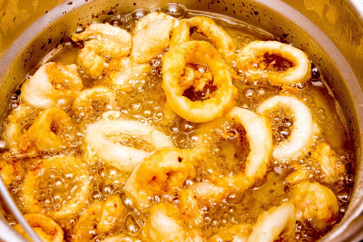 Calamari rings frying in oil in a silver pot