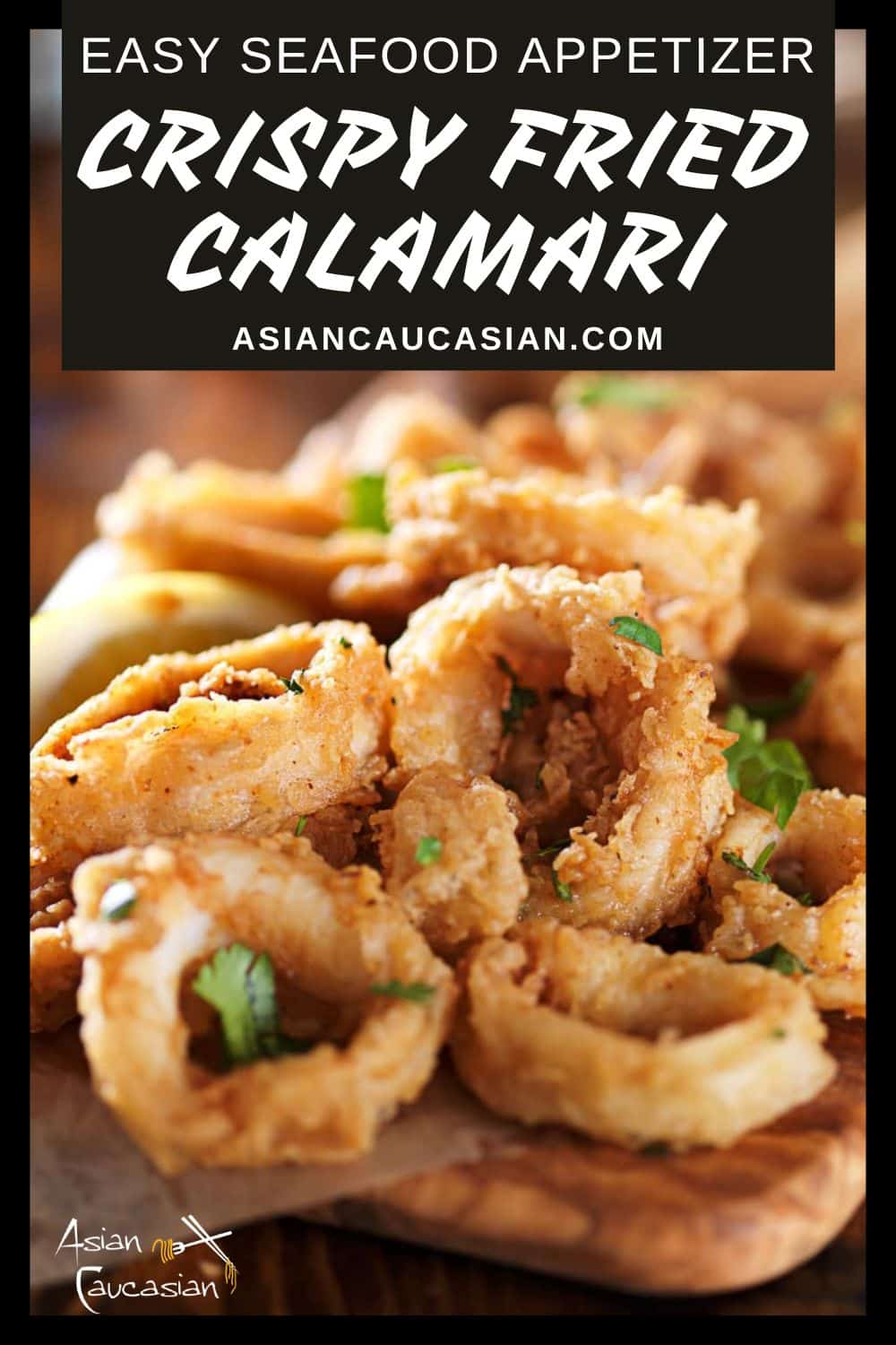 Fried and crispy calamari rings on a wooden board with lemon wedges on the side.