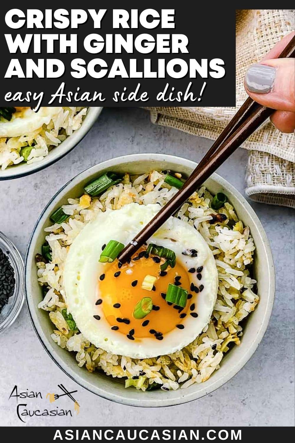 Crispy rice with ginger and scallions in a bowl topped with a runny fried egg with a pair of brown chopsticks, and a linen napkin on the side.
