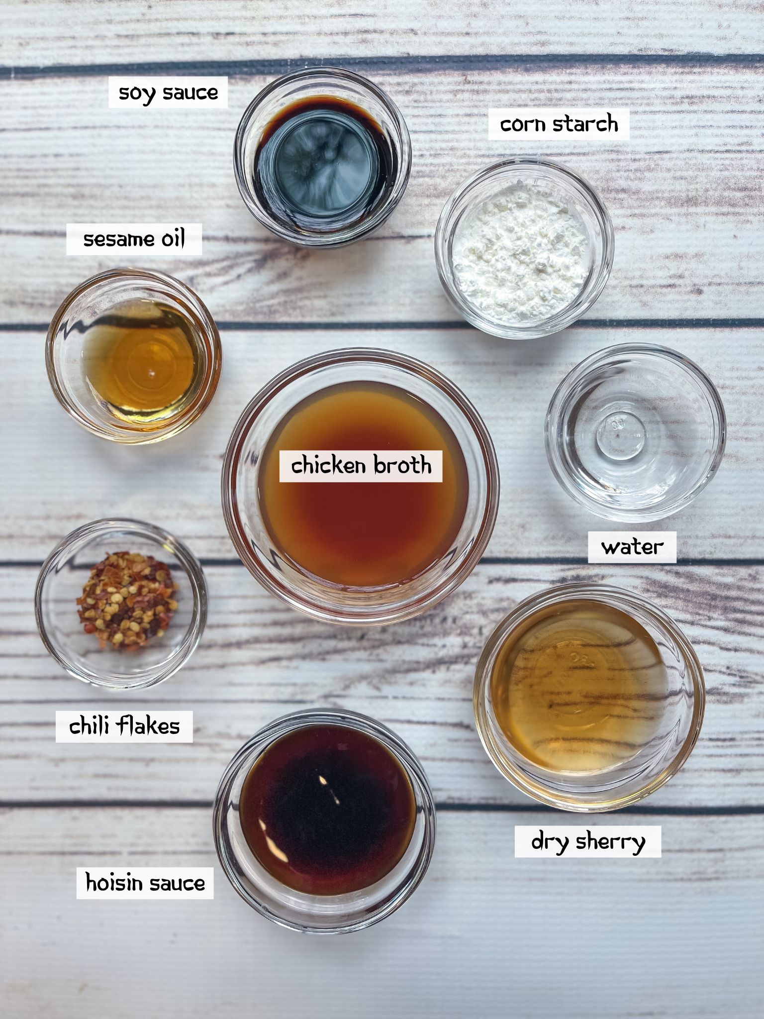 Labeled ingredients in small clear bowls for making the sauce for beef and broccoli stir fry.