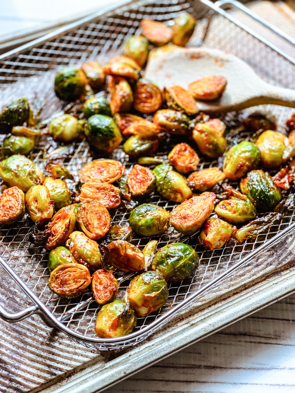 Air fryer brussels sprouts with gochujang in a silver basket right out of the air fryer.