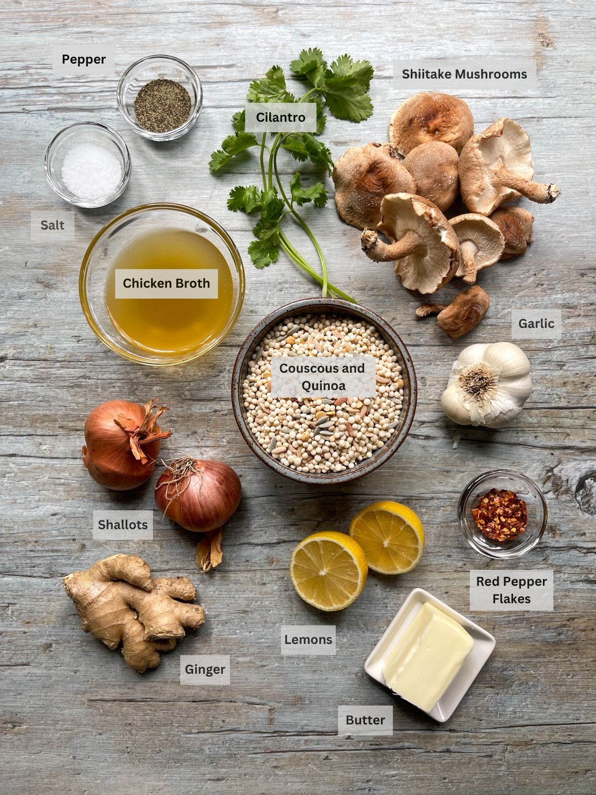 Labeled ingredients for making couscous and quinoa with shiitake mushrooms on top of a wooden board.